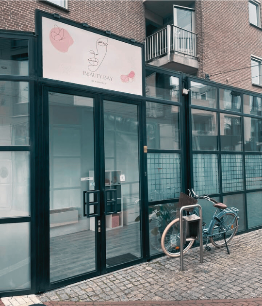 De voorgevel van Beauty Bay by Patrycja met het logo boven de deur en een fiets in het fietsenrek